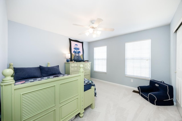 bedroom featuring a ceiling fan, light colored carpet, and baseboards