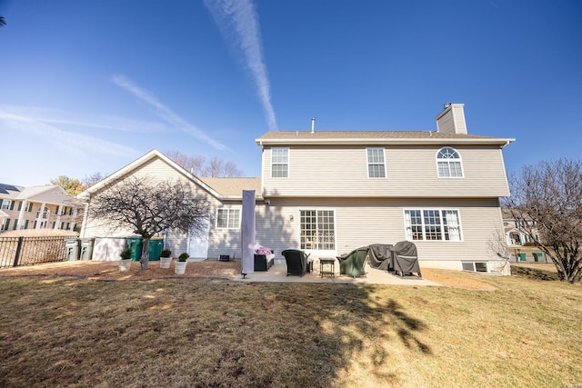 rear view of house featuring a patio area, a yard, a chimney, and fence