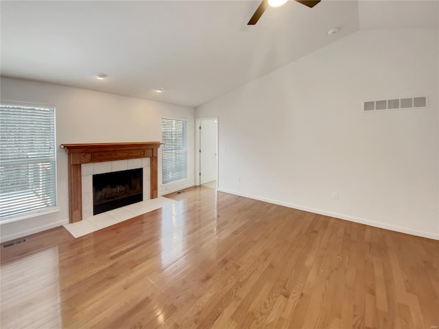 unfurnished living room featuring vaulted ceiling, a fireplace, and light wood-style floors