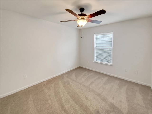 unfurnished room featuring baseboards, a ceiling fan, and light colored carpet