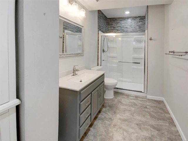 full bathroom with a stall shower, baseboards, vanity, and toilet