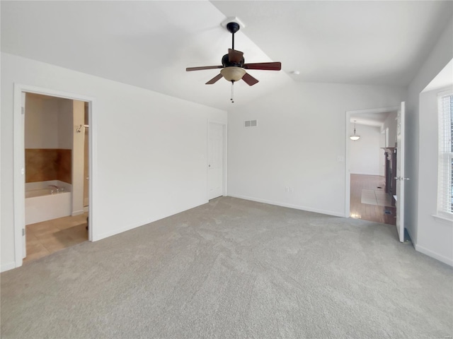 unfurnished bedroom with visible vents, connected bathroom, lofted ceiling, ceiling fan, and carpet floors