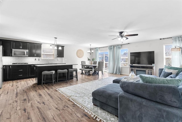 living area with light wood-type flooring and a ceiling fan