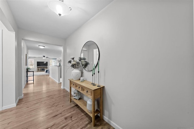 hallway with baseboards and light wood-style flooring