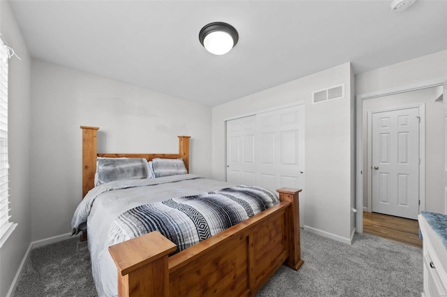 bedroom featuring visible vents, light colored carpet, a closet, and baseboards