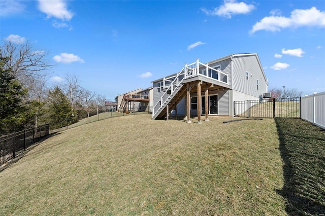 rear view of property with a yard, a wooden deck, a fenced backyard, and stairs