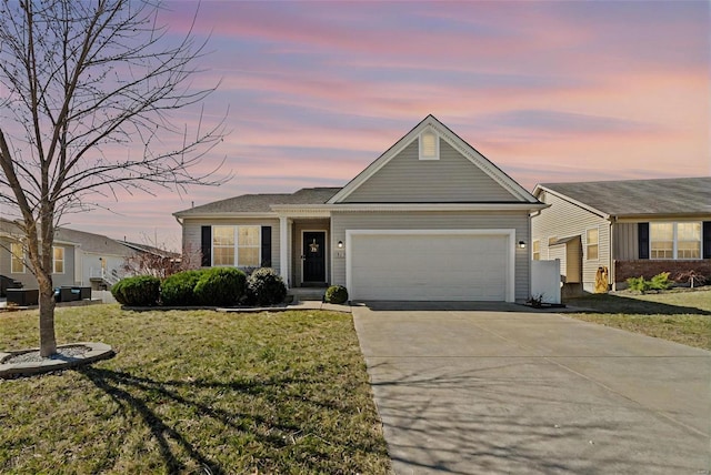 single story home featuring a garage, a yard, and concrete driveway