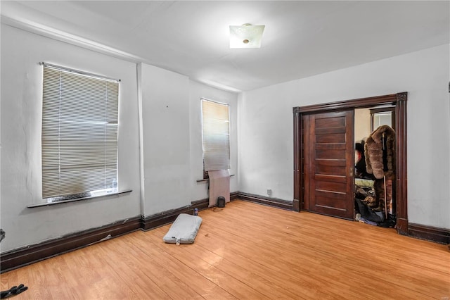 unfurnished bedroom featuring light wood-type flooring and baseboards