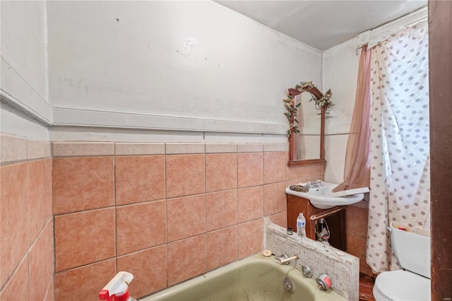 bathroom featuring toilet, a washtub, and tile walls