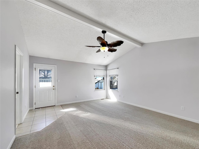 carpeted entrance foyer with a ceiling fan, vaulted ceiling with beams, plenty of natural light, and a textured ceiling