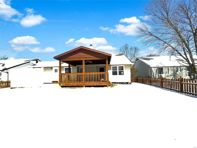 snow covered property with fence and a wooden deck