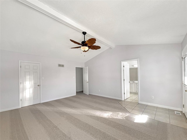 interior space featuring visible vents, lofted ceiling with beams, ceiling fan, a textured ceiling, and baseboards