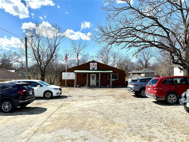 exterior space with uncovered parking and metal roof