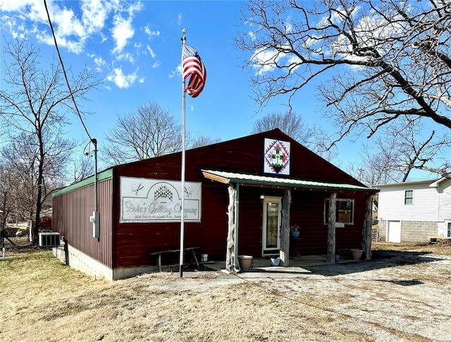 view of front of house with covered porch, central AC unit, and metal roof