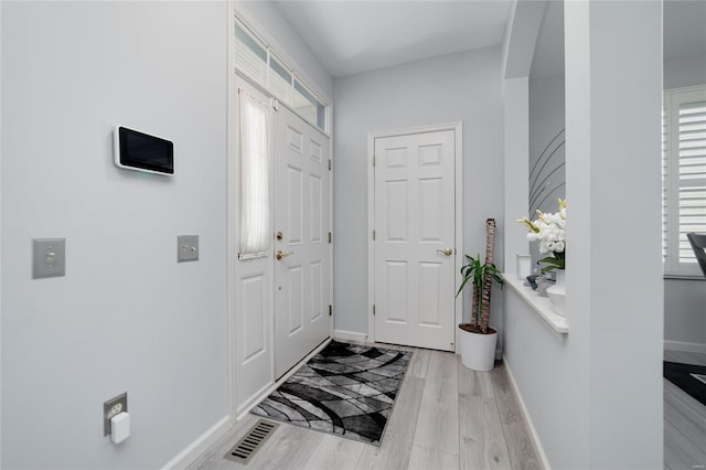 foyer with a healthy amount of sunlight, light wood-style flooring, and baseboards