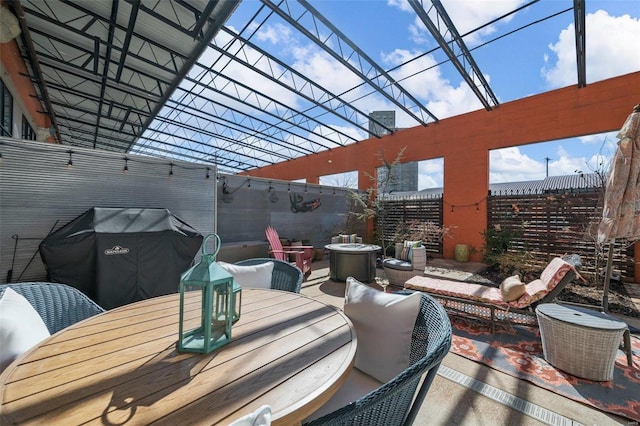 deck featuring outdoor dining area, a fenced backyard, a fire pit, grilling area, and a patio area