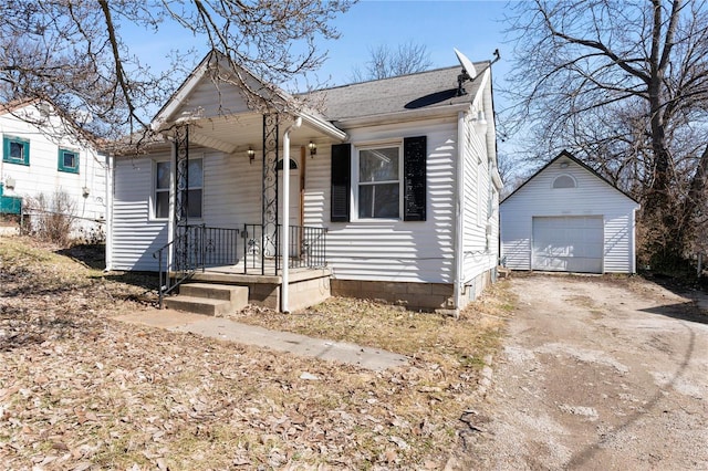 view of front of home with an outbuilding, driveway, roof with shingles, and a garage