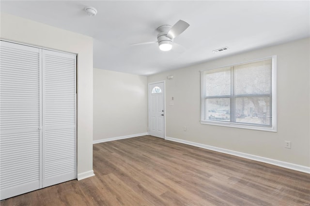 entryway with a ceiling fan, visible vents, baseboards, and wood finished floors