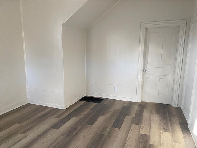 additional living space featuring baseboards, lofted ceiling, and dark wood-style flooring