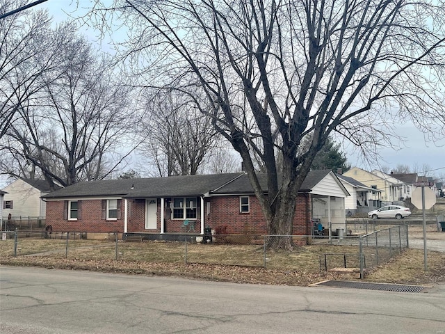 single story home with brick siding, a fenced front yard, and a residential view