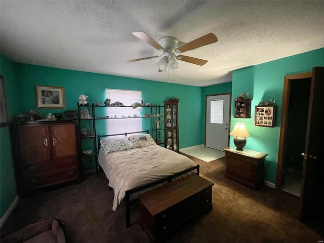 carpeted bedroom featuring a textured ceiling, a ceiling fan, and baseboards