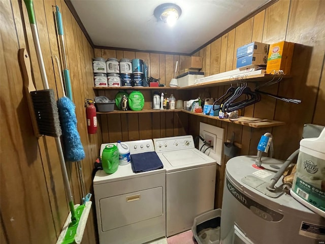 washroom with washer and dryer, laundry area, water heater, and wooden walls