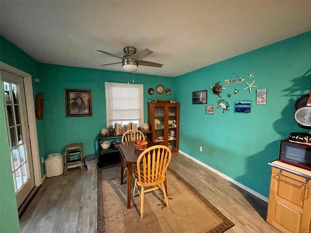 dining area featuring ceiling fan, baseboards, and wood finished floors