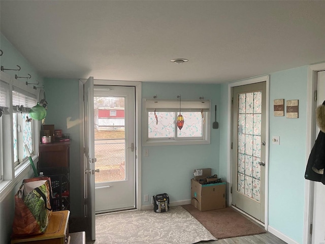 doorway to outside with a wealth of natural light and baseboards