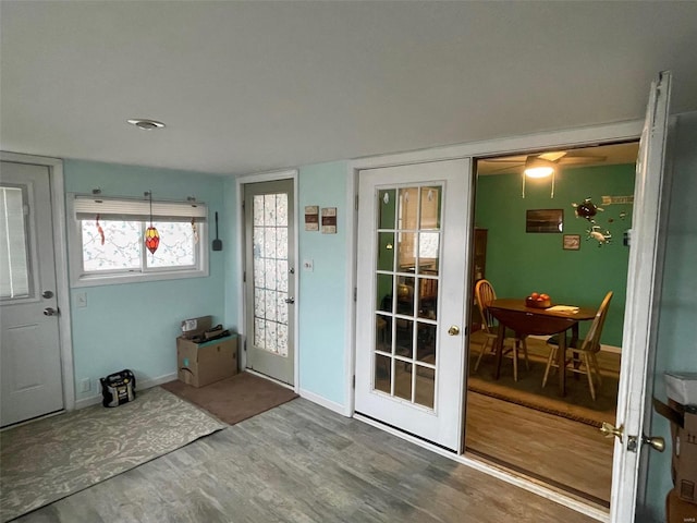 doorway to outside featuring baseboards and wood finished floors