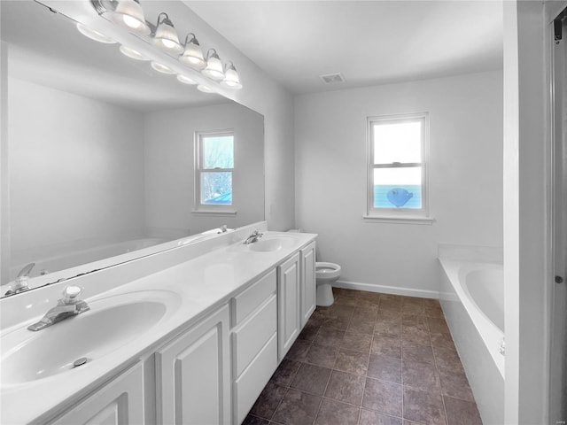 bathroom with toilet, a garden tub, double vanity, and a sink