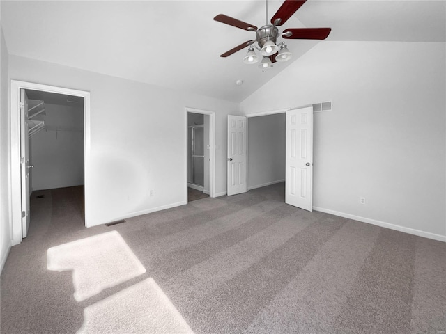 unfurnished bedroom with carpet floors, high vaulted ceiling, a spacious closet, and visible vents