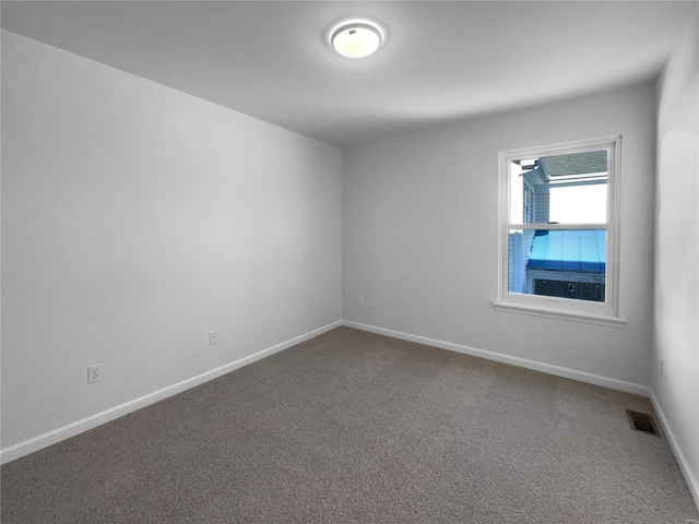 carpeted spare room with baseboards and visible vents