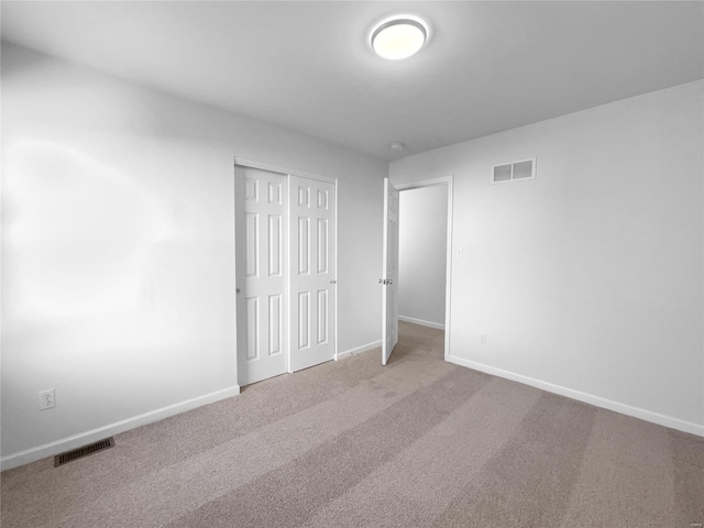 unfurnished bedroom with carpet flooring, visible vents, and baseboards