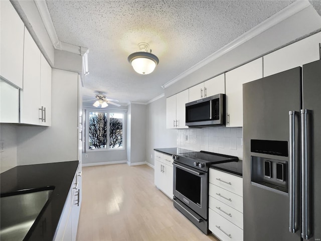 kitchen featuring stainless steel appliances, backsplash, ornamental molding, white cabinetry, and a sink