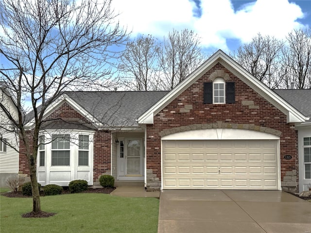 view of front of house with driveway, brick siding, an attached garage, and a front yard