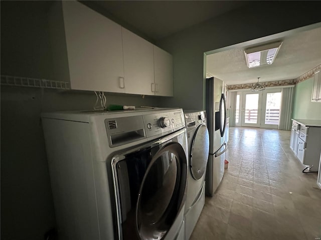 laundry area with cabinet space, washing machine and dryer, and french doors