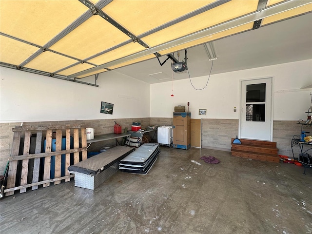 garage with a garage door opener and wainscoting