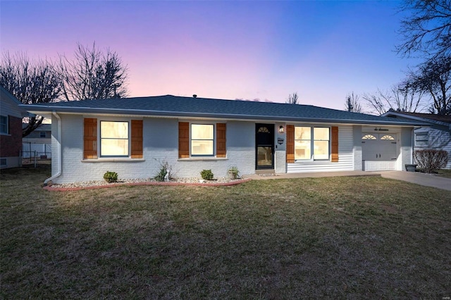 ranch-style house featuring a front yard, an attached garage, brick siding, and concrete driveway