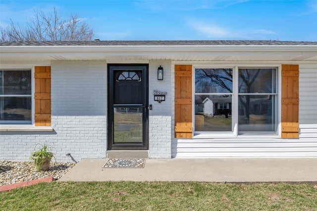 property entrance featuring brick siding