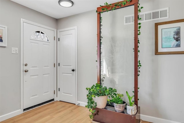 entryway with visible vents, light wood-type flooring, and baseboards