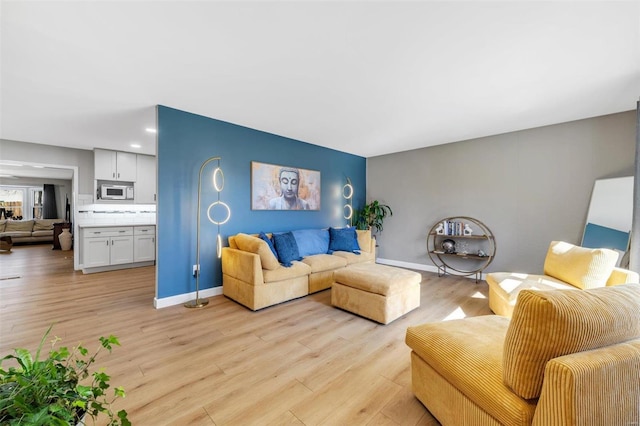 living area with light wood-style flooring and baseboards