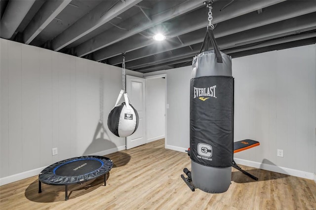 exercise area featuring baseboards and wood finished floors