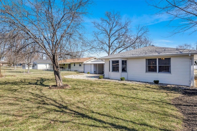 back of house with a lawn and fence