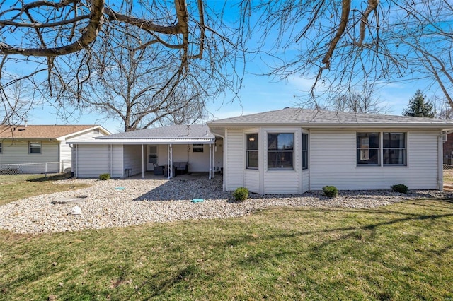 exterior space featuring a yard, an attached carport, and fence