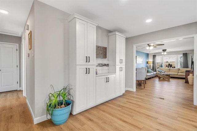 hallway with recessed lighting, baseboards, and light wood-style floors