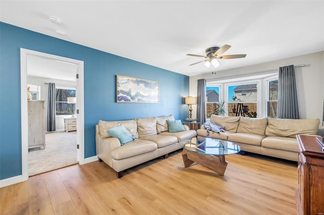 living room featuring wood finished floors, baseboards, and ceiling fan