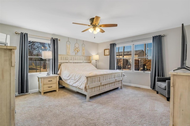 bedroom with multiple windows, a ceiling fan, baseboards, and carpet floors