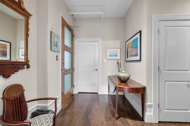 entryway with dark wood-style floors and baseboards