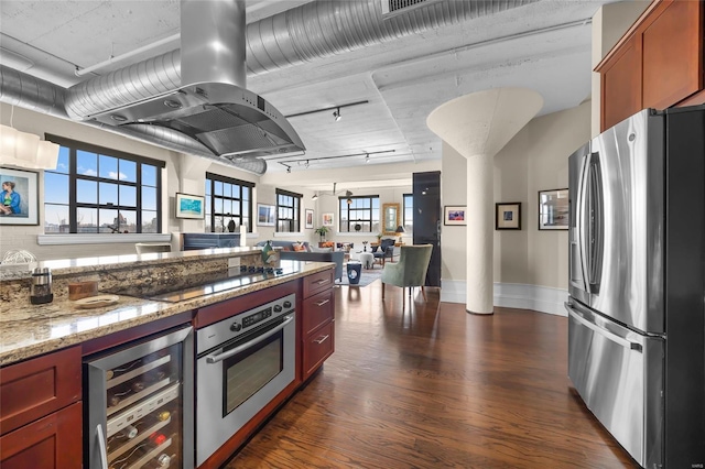 kitchen featuring wine cooler, dark wood-type flooring, light stone countertops, island exhaust hood, and stainless steel appliances