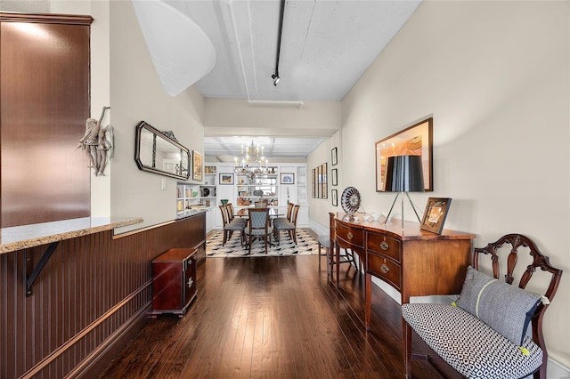 interior space with dark wood-type flooring, rail lighting, and a notable chandelier